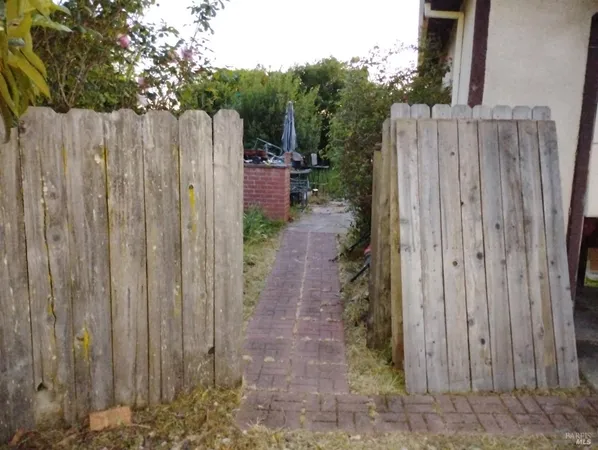 a view of a backyard with wooden fence
