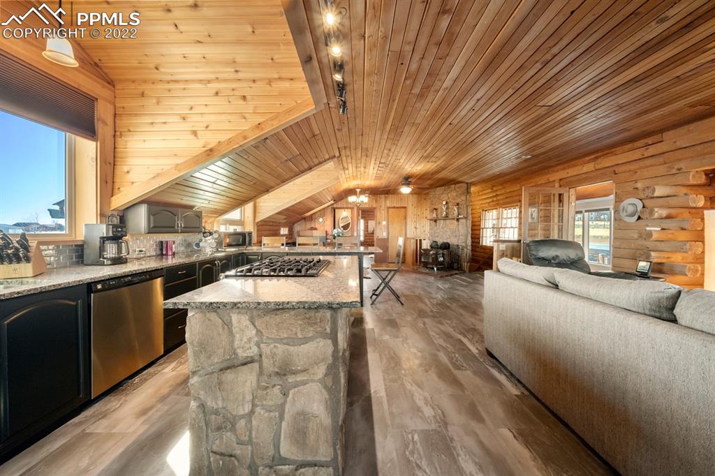 3645 Doolittle Road Monument, CO 80132 - Photo 4 of 39 a large kitchen with stainless steel appliances kitchen island granite countertop a large kitchen counter top a stove and a sink with couches