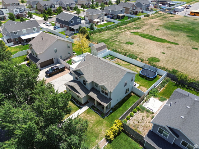 1393 West 150 North Springville, UT 84663 - Photo 25 of 31 Two-story residence featuring a covered front porch, an attached garage, a fenced backyard with green lawn, a white vinyl perimeter fence, and mature landscaping