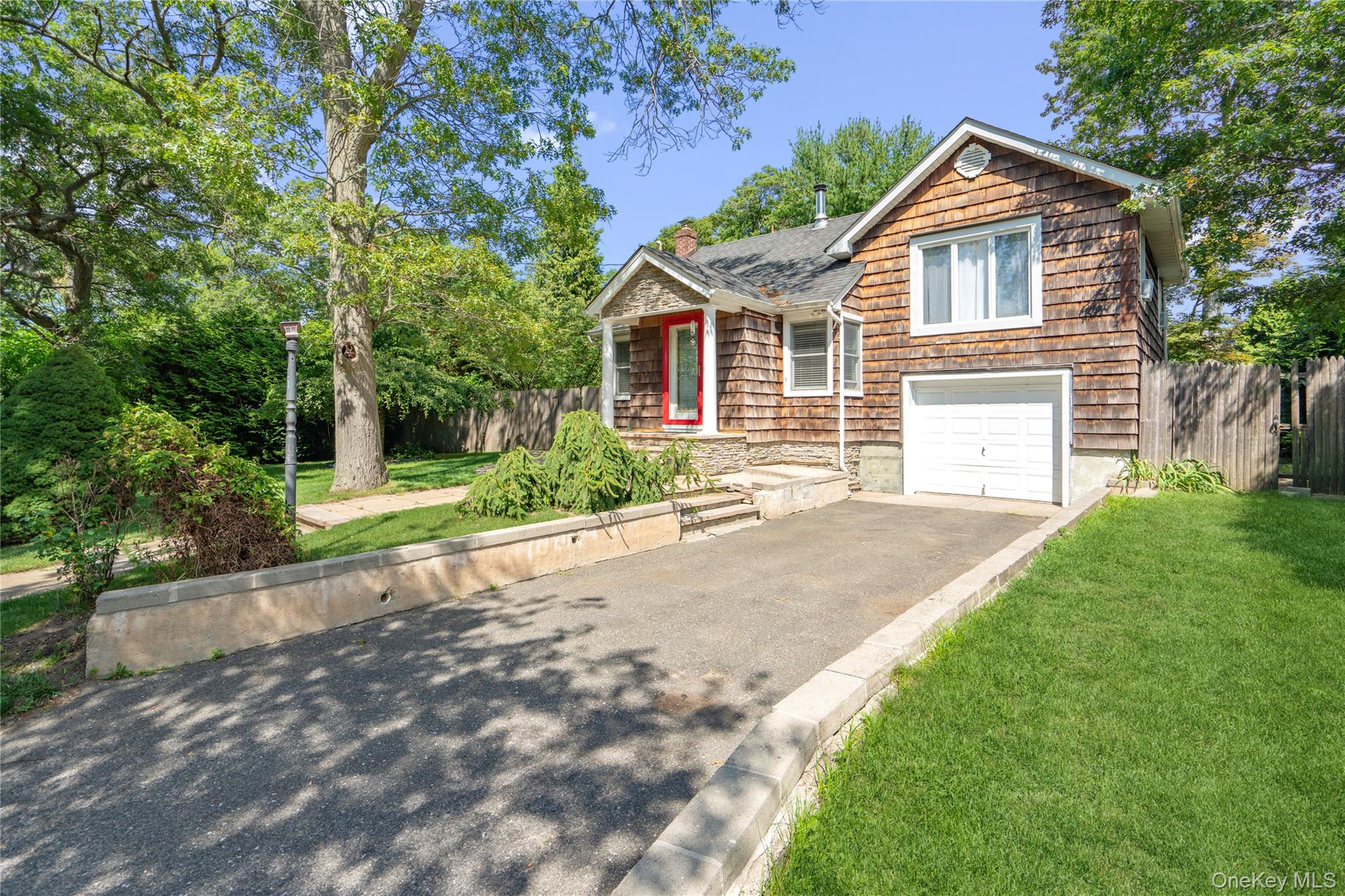 17 Tulip Road Rocky Point, NY 11778 - Photo 2 of 24 a front view of a house with a yard and garage