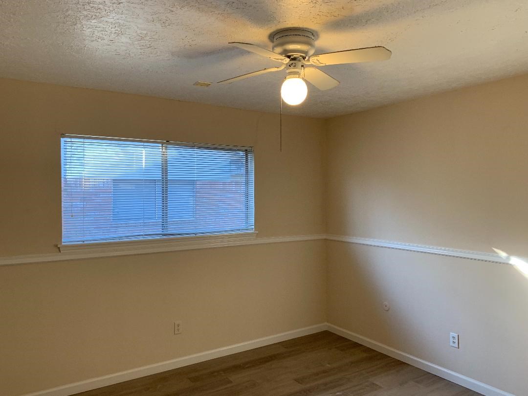 13819 Piping Rock Lane Houston, TX 77077 - Photo 13 of 16 an empty room with a ceiling fan and wooden floor