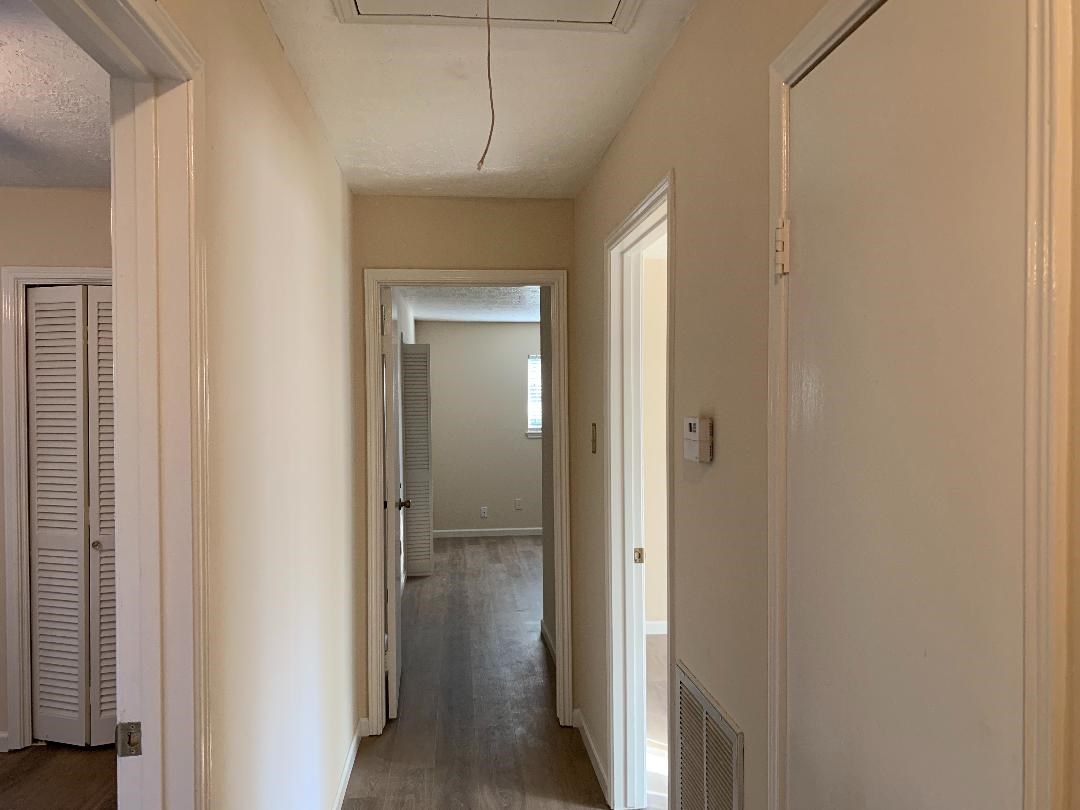 13819 Piping Rock Lane Houston, TX 77077 - Photo 9 of 16 a view of a hallway with a wooden door