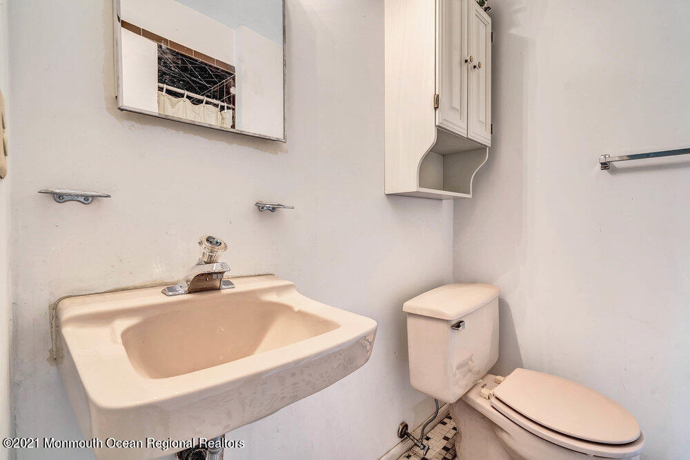 60 Charles Drive Tinton Falls, NJ 07753 - Photo 16 of 23 a bathroom with a toilet a sink and mirror