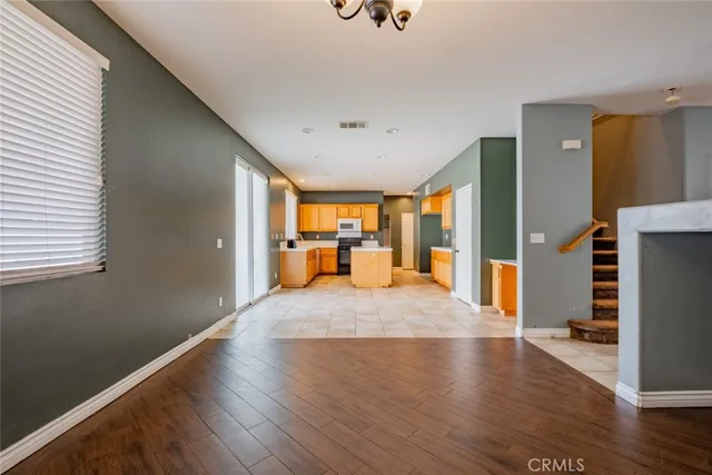 a large bedroom with wooden floor and windows
