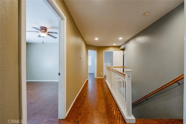 a view of a hallway with wooden floor and staircase