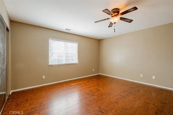 an empty room with a window and a fan