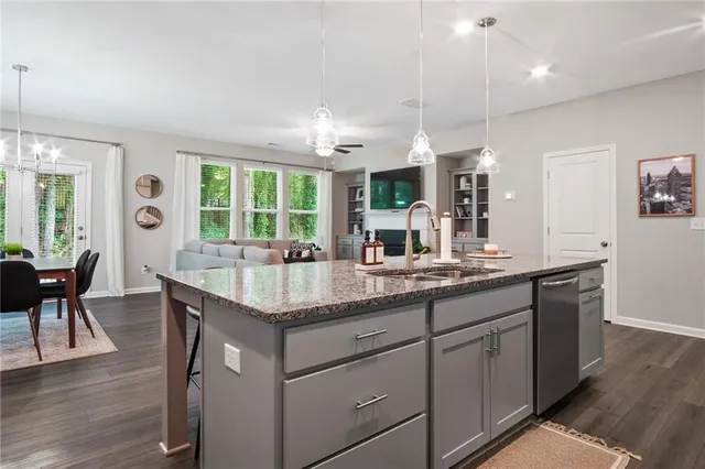 a kitchen with granite countertop cabinets a sink dining table and chairs