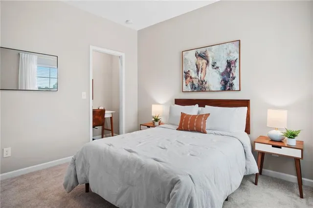 a bedroom with a bed and painting on the wall