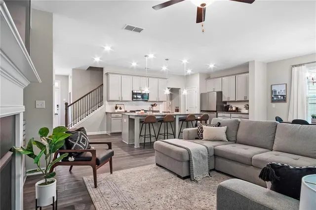 a living room with furniture and a dining table with kitchen view