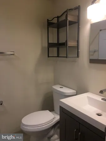 a bathroom with a toilet a sink and mirror