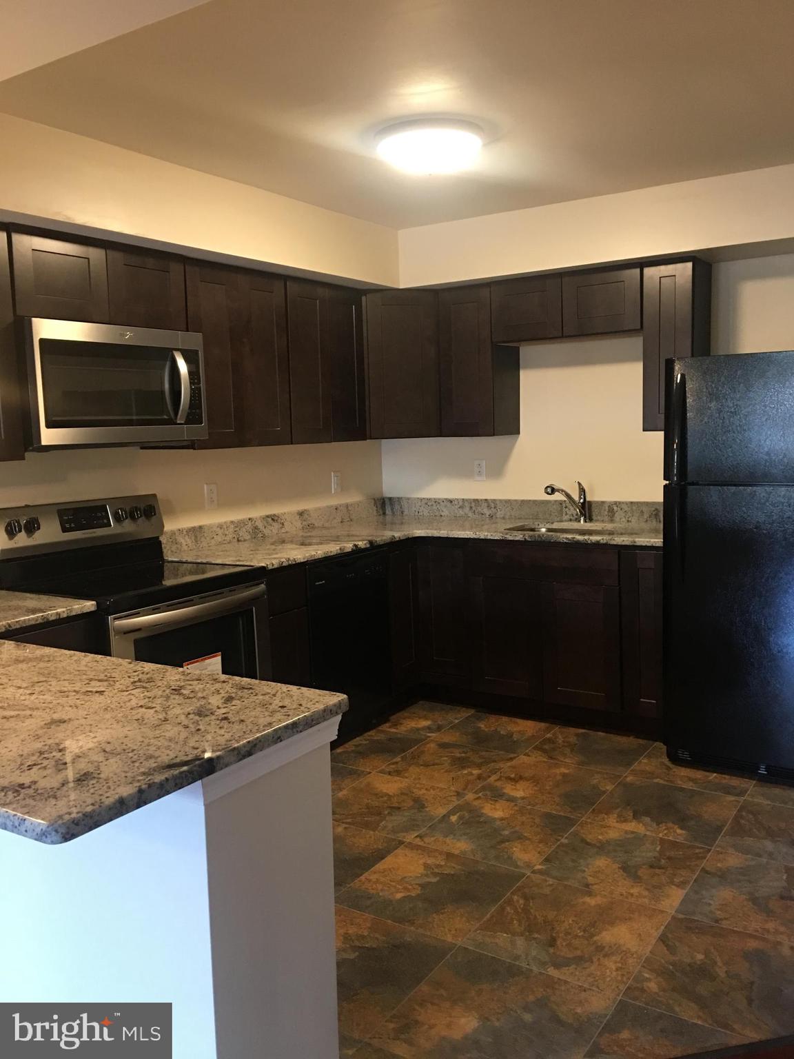 1 Pennsylvania Road, Unit 4 Glassboro, NJ 08028 - Photo 27 of 37 a kitchen with kitchen island sink and refrigerator
