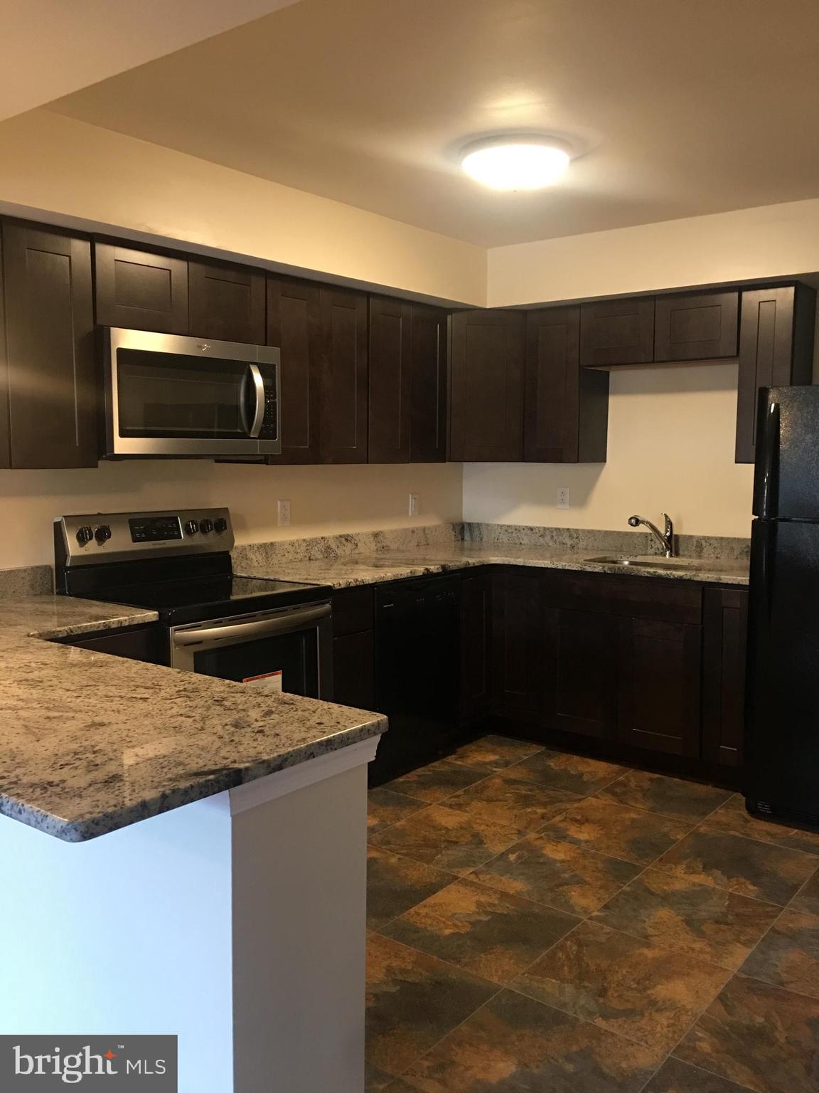 1 Pennsylvania Road, Unit 4 Glassboro, NJ 08028 - Photo 31 of 37 a kitchen with kitchen island sink and refrigerator