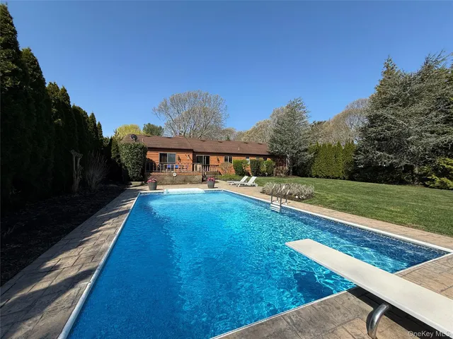 a view of a house with backyard and sitting area