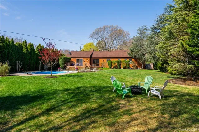 a view of yard with table and chairs under an umbrella