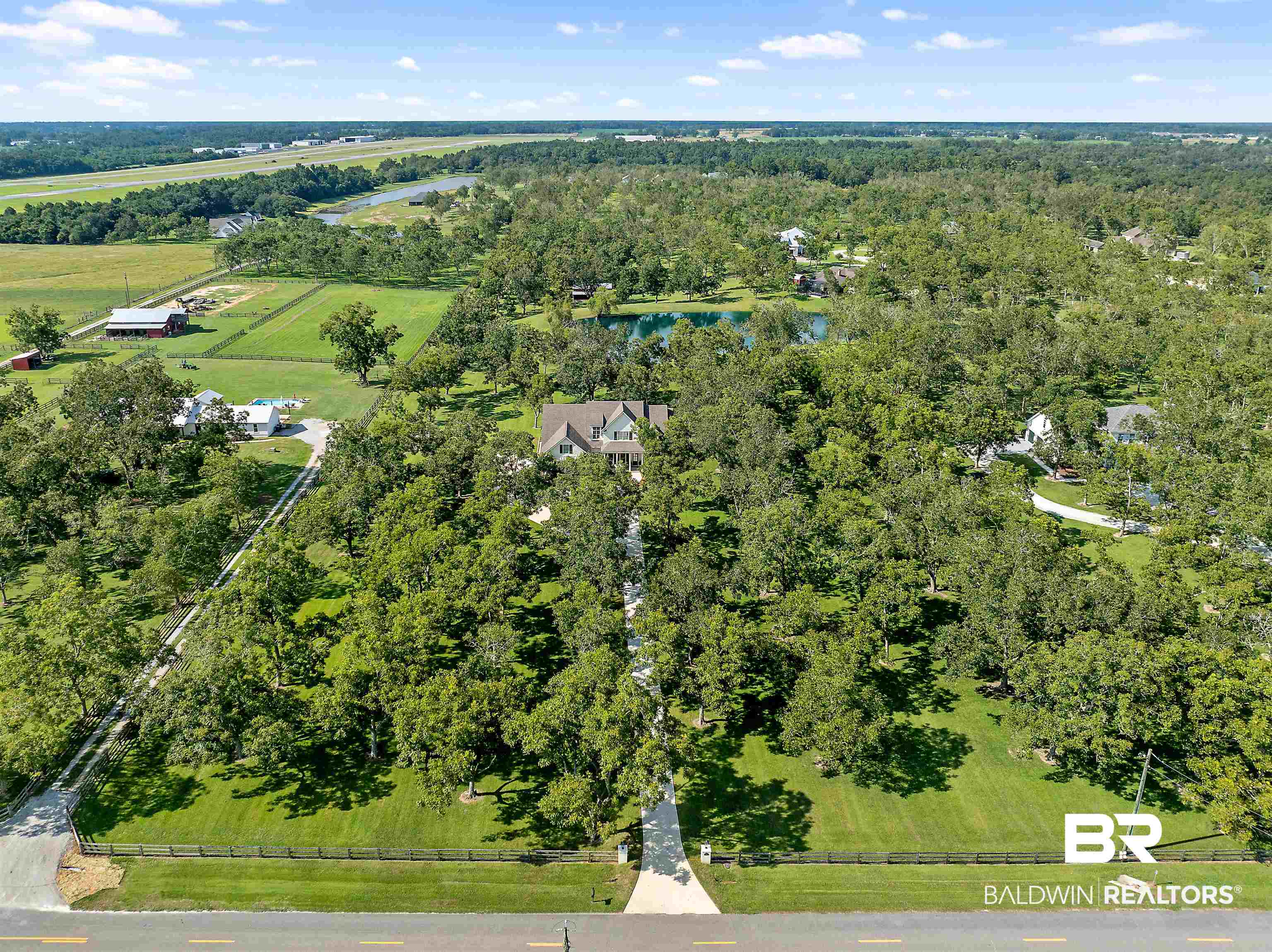 8753 Bishop Road Fairhope, AL 36532 - Photo 59 of 59 Expansive property featuring a central residence, a private pond, mature trees, and a paved driveway