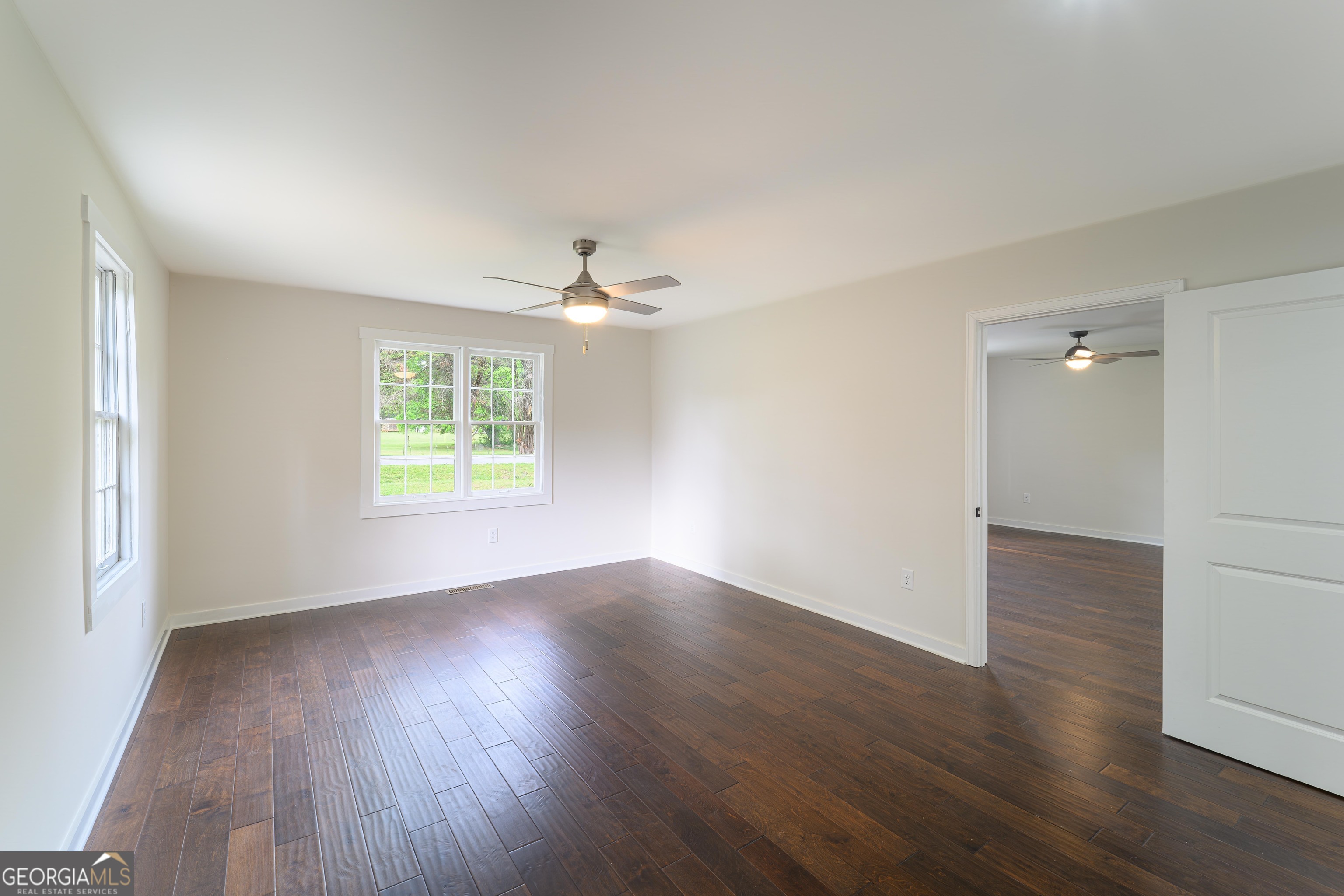 418 Lamb Road Moreland, GA 30259 - Photo 13 of 32 an empty room with wooden floor chandelier and windows