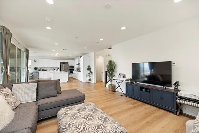 a large white kitchen with a large window and stainless steel appliances