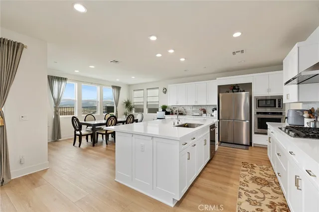 a kitchen with stainless steel appliances kitchen island granite countertop a refrigerator and a stove top oven