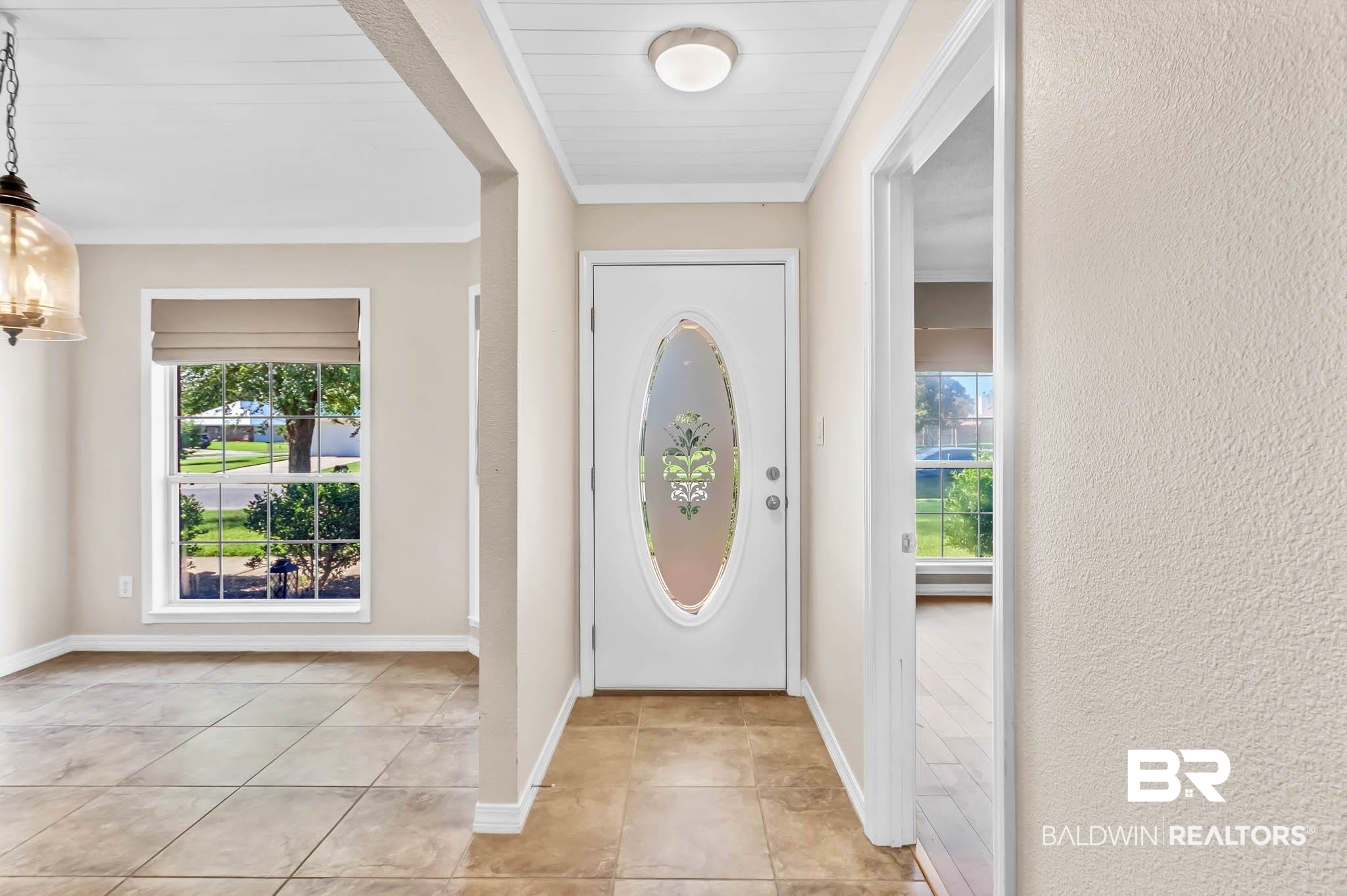 9607 Czar Court Fairhope, AL 36532 - Photo 7 of 42 Entrance foyer featuring a chandelier, a textured wall, light tile patterned floors, and crown molding