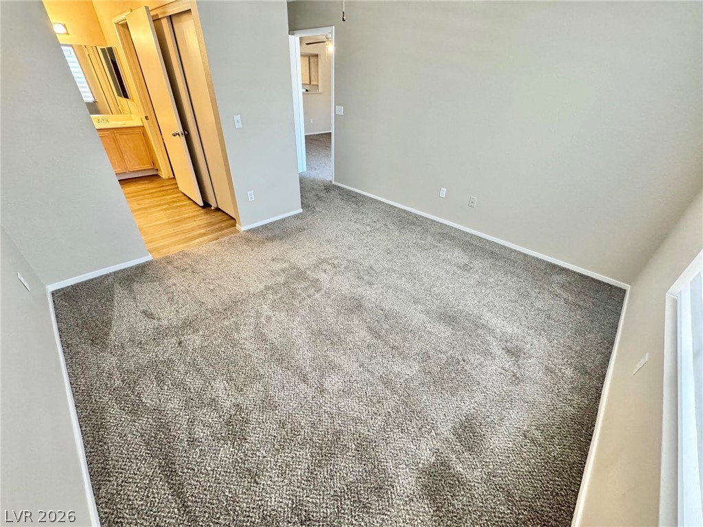 8070 West Russell Road, Unit 2121 Las Vegas, NV 89113 - Photo 15 of 22 A spacious room featuring comfortable carpeting, offering a seamless transition to the adjacent bathroom with hard flooring.