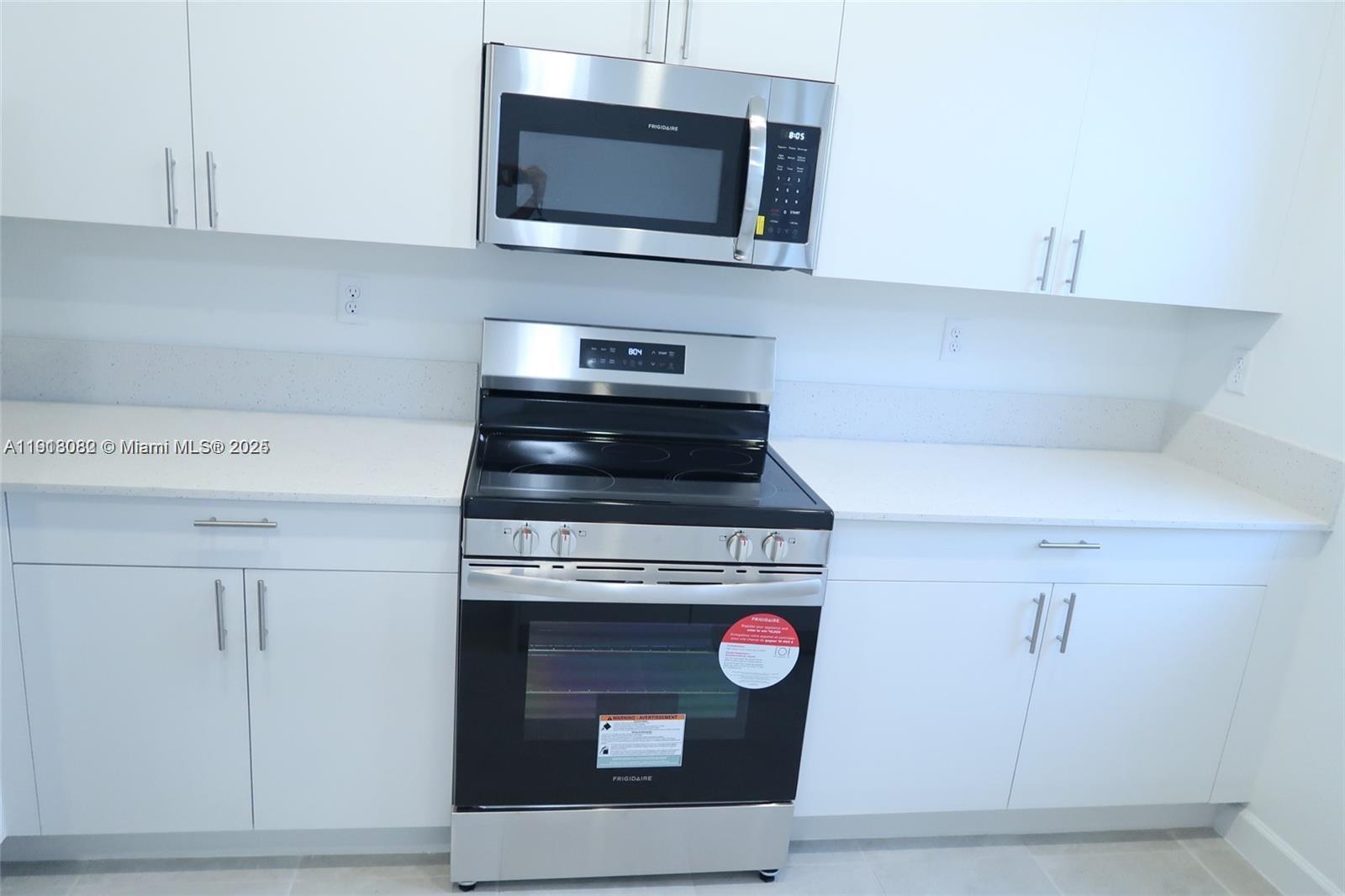 12946 Southwest 231st Street Miami, FL 33170 - Photo 14 of 42 a kitchen with a stove and a microwave