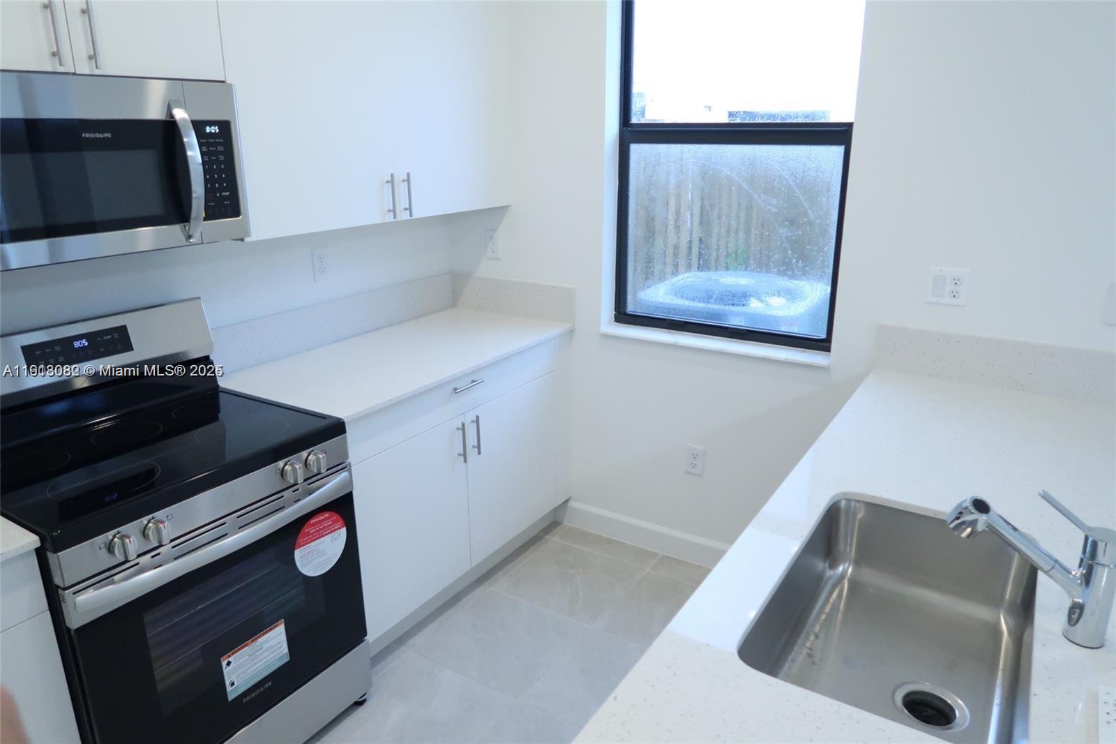 12946 Southwest 231st Street Miami, FL 33170 - Photo 15 of 42 a kitchen with a stove and a sink
