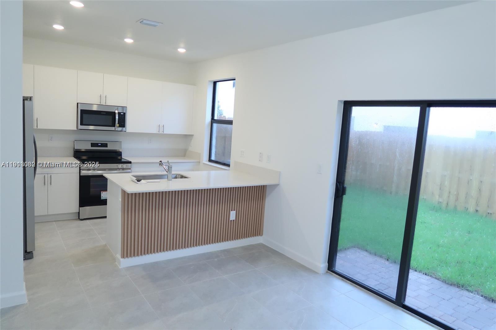 12946 Southwest 231st Street Miami, FL 33170 - Photo 6 of 42 a kitchen with stainless steel appliances granite countertop a stove a sink and a refrigerator
