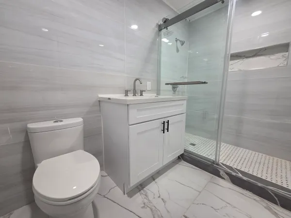 a bathroom with a sink a toilet and shower