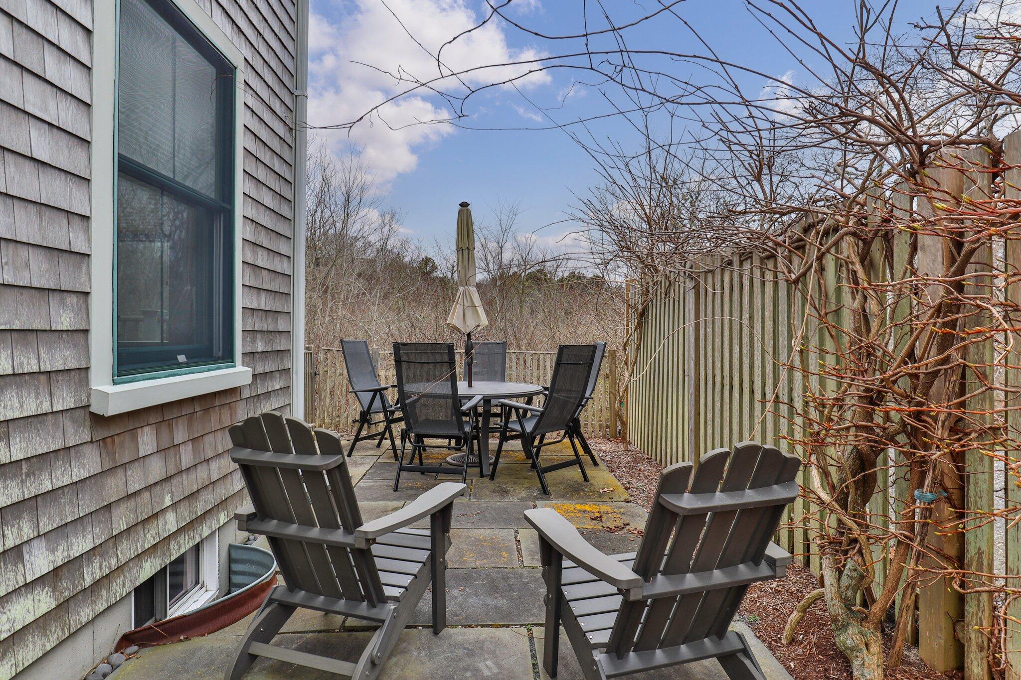 16 Meadow Road, Unit 16 Provincetown, MA 02657 - Photo 9 of 23 a view of a patio with table and chairs and floor to ceiling window
