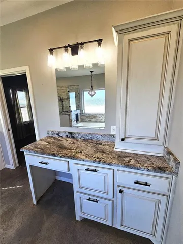 a bathroom with a granite countertop sink a toilet and a mirror