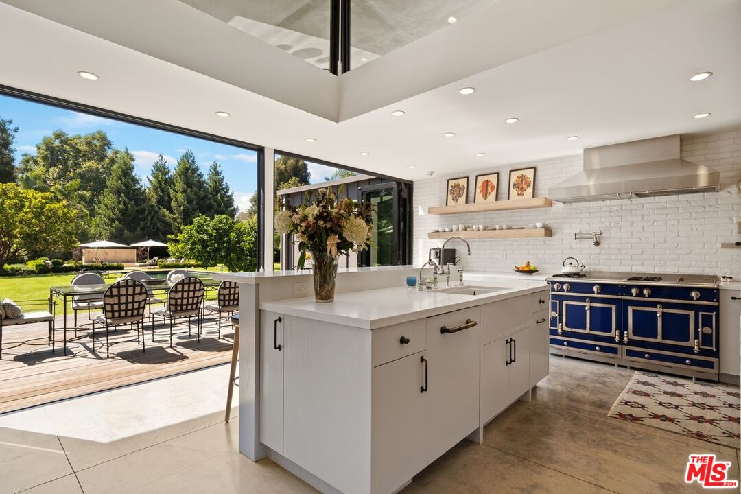 6237 Bonsall Drive Malibu, CA 90265 - Photo 11 of 50 a kitchen with stainless steel appliances kitchen island a large counter top a stove and a sink