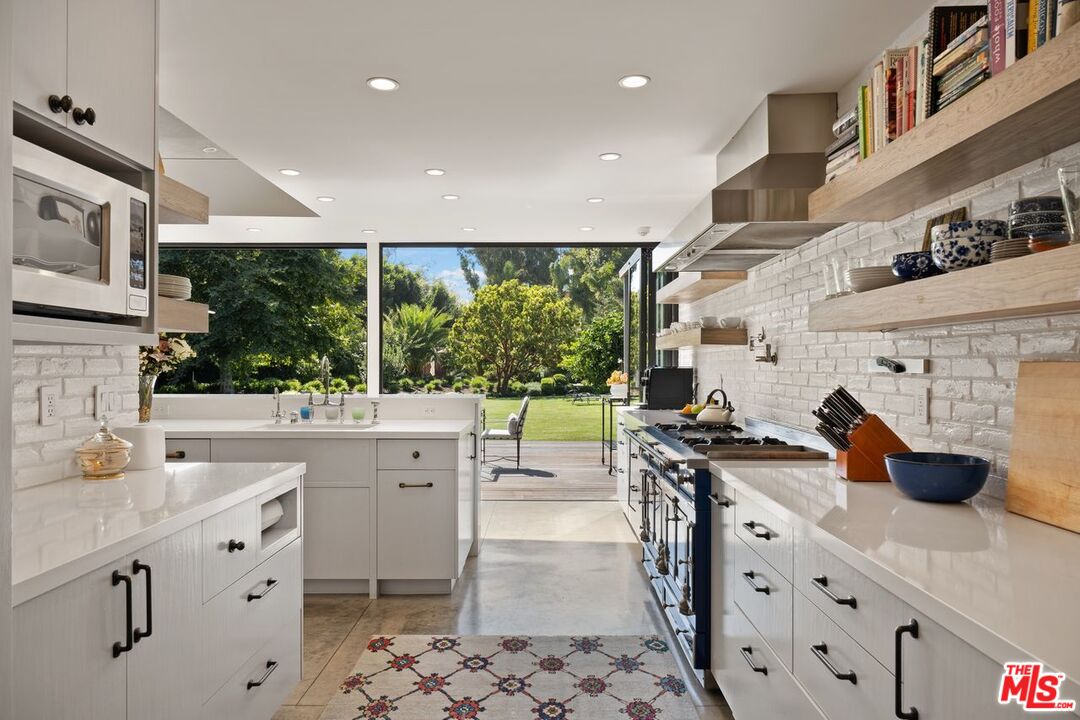 6237 Bonsall Drive Malibu, CA 90265 - Photo 13 of 50 a kitchen with stainless steel appliances a sink stove and cabinets