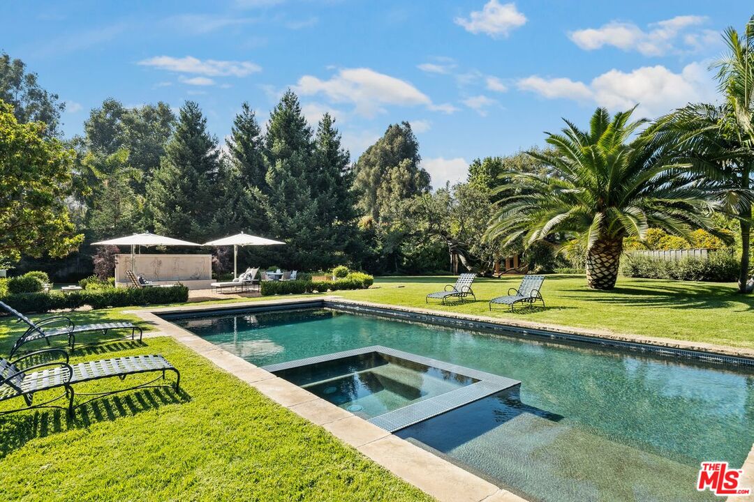 6237 Bonsall Drive Malibu, CA 90265 - Photo 40 of 50 a view of a swimming pool with a lawn chairs under an umbrella