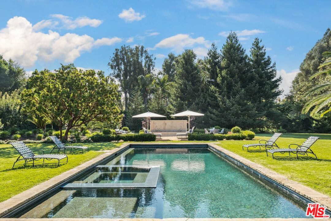 6237 Bonsall Drive Malibu, CA 90265 - Photo 41 of 50 a view of a swimming pool with a bench and trees in the background