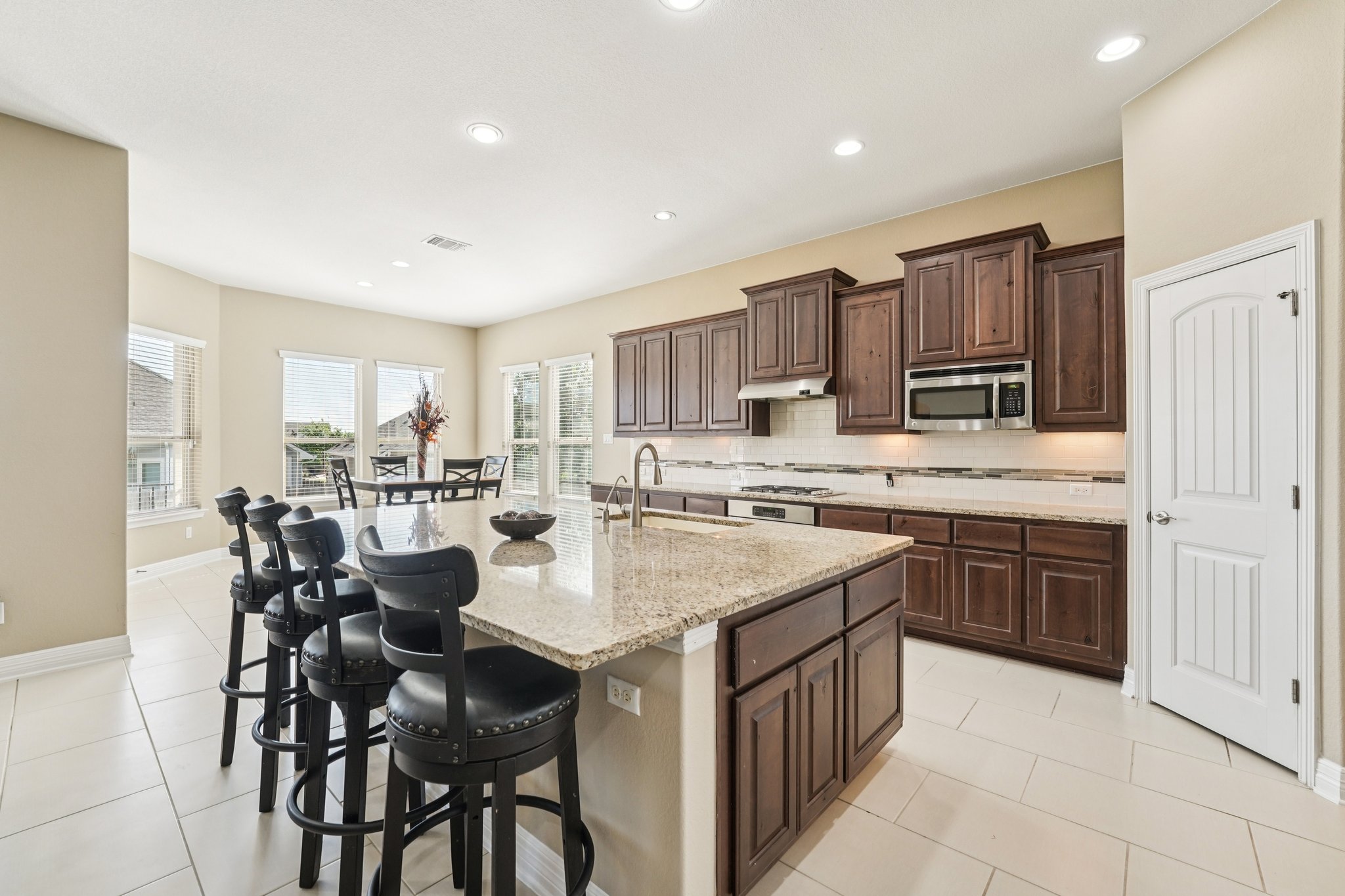 18117 Monarch Butterfly Way Pflugerville, TX 78660 - Photo 2 of 19 A spacious center island with bar seating anchors the space for cooking, gathering, and connection.