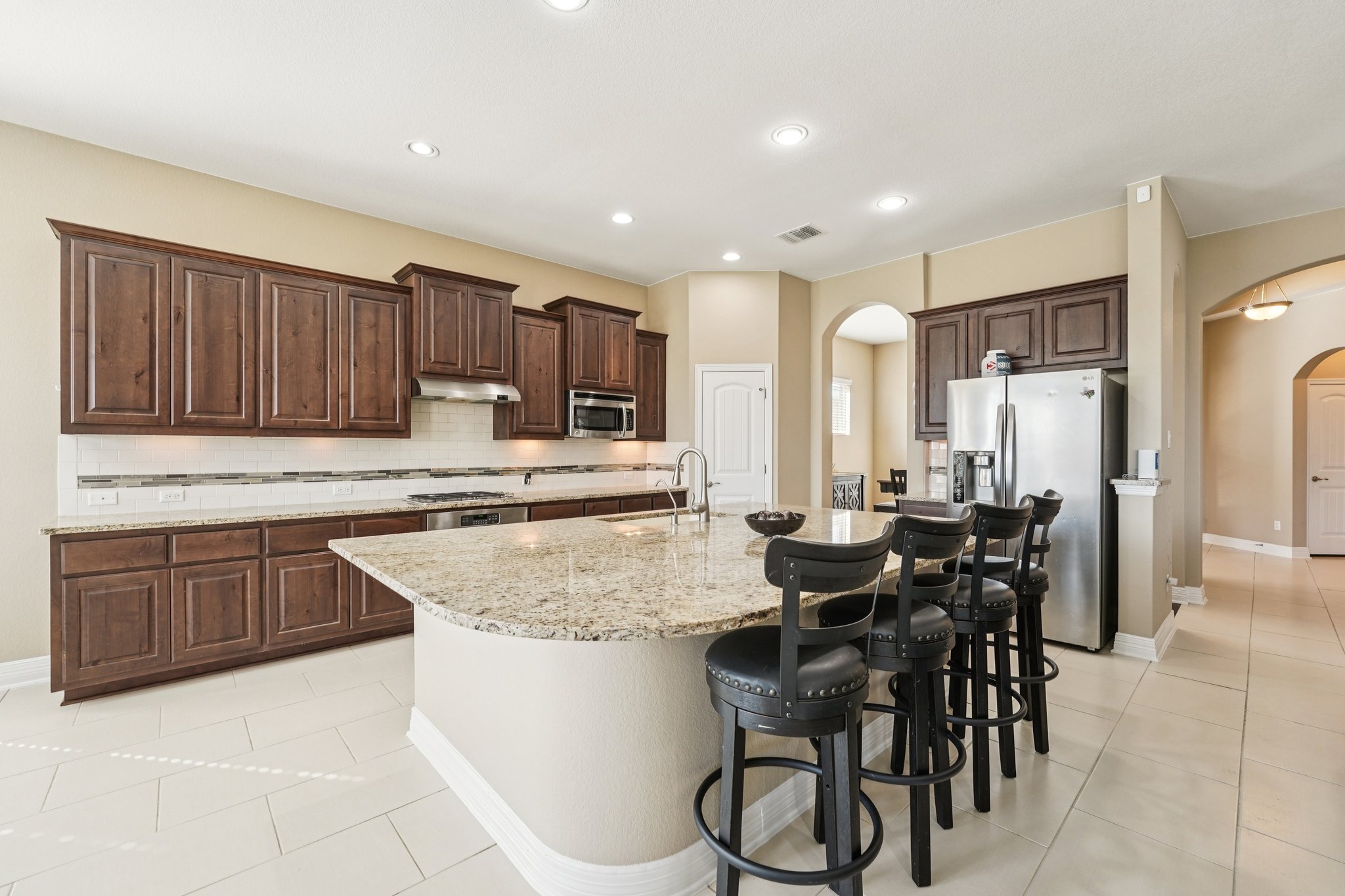 18117 Monarch Butterfly Way Pflugerville, TX 78660 - Photo 5 of 19 A spacious center island with bar seating anchors the space for cooking, gathering, and connection.