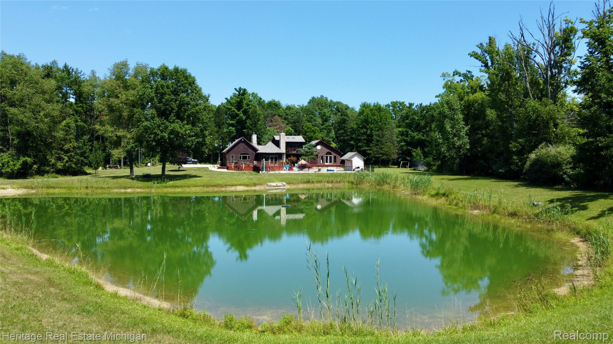 1888 Germany Road Williamston, MI 48895 - Photo 51 of 57 Expansive pond with tranquil green water and lush surrounding grass