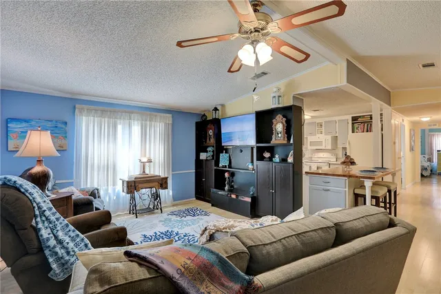 a living room with furniture kitchen and a chandelier