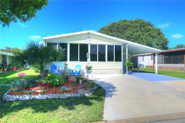 a front view of a house with a yard and potted plants