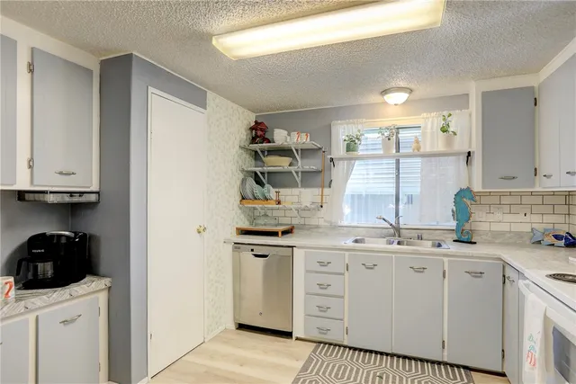 a kitchen with a sink window and cabinets