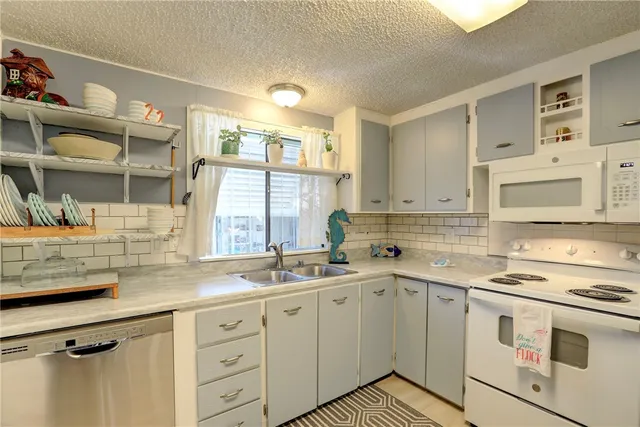 a kitchen with cabinets appliances a sink and a counter top space