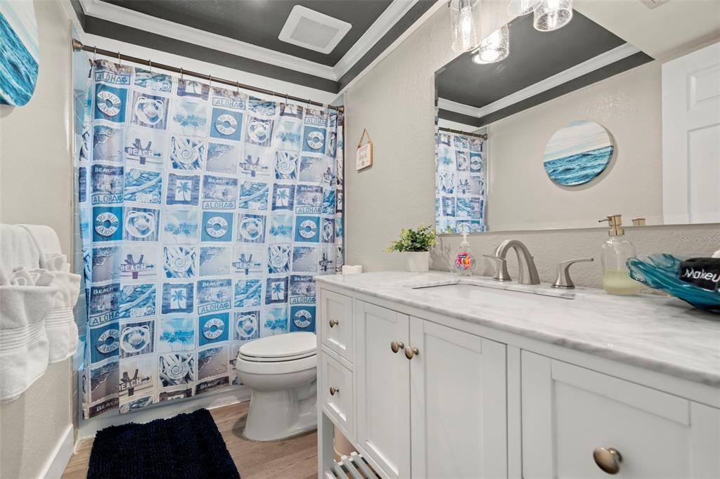 14030 79th Avenue Seminole, FL 33776 - Photo 23 of 33 a bathroom with a granite countertop sink a toilet and a shower