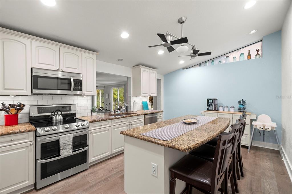 14030 79th Avenue Seminole, FL 33776 - Photo 4 of 33 a kitchen with a stove a sink and chairs