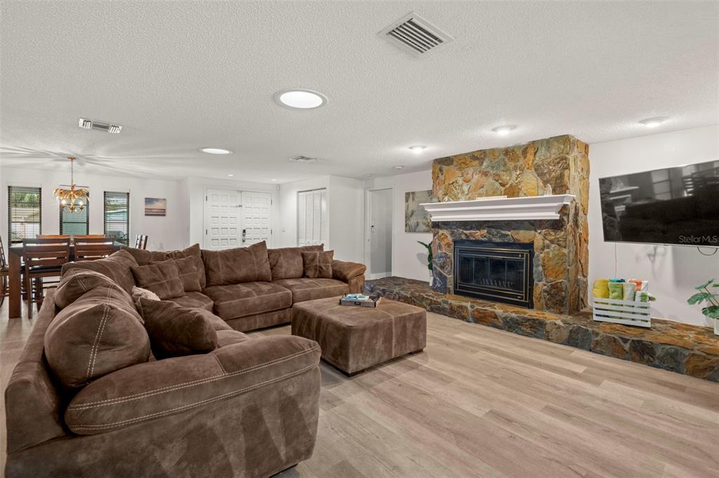 14030 79th Avenue Seminole, FL 33776 - Photo 8 of 33 a living room with furniture a flat screen tv and a fireplace