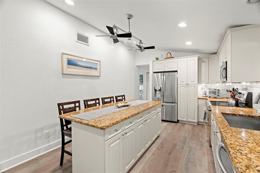 14030 79th Avenue Seminole, FL 33776 - Photo 9 of 33 a living room with stainless steel appliances kitchen island granite countertop furniture a refrigerator a sink and a stove