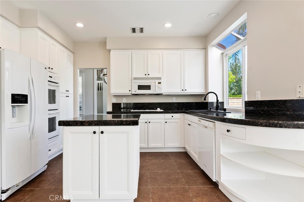 5149 Pesto Way Oak Park, CA 91377 - Photo 11 of 42 a kitchen with granite countertop white cabinets and white appliances