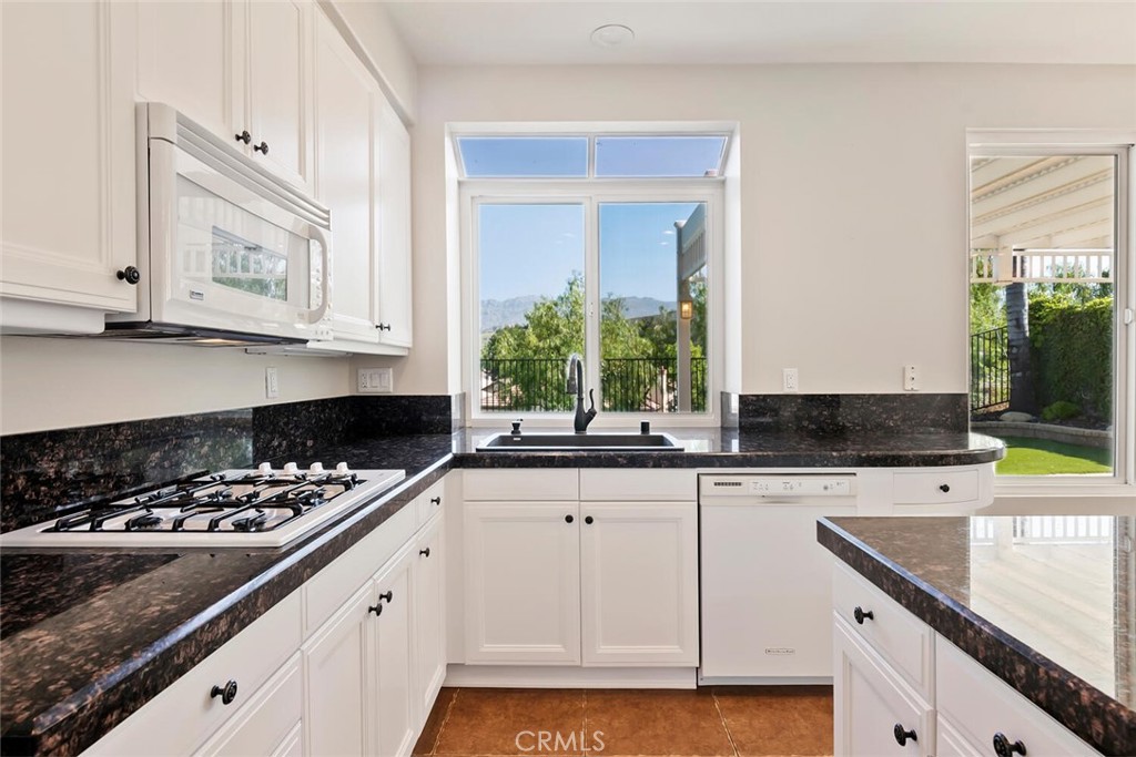 5149 Pesto Way Oak Park, CA 91377 - Photo 13 of 42 a kitchen with granite countertop a sink a stove and cabinets