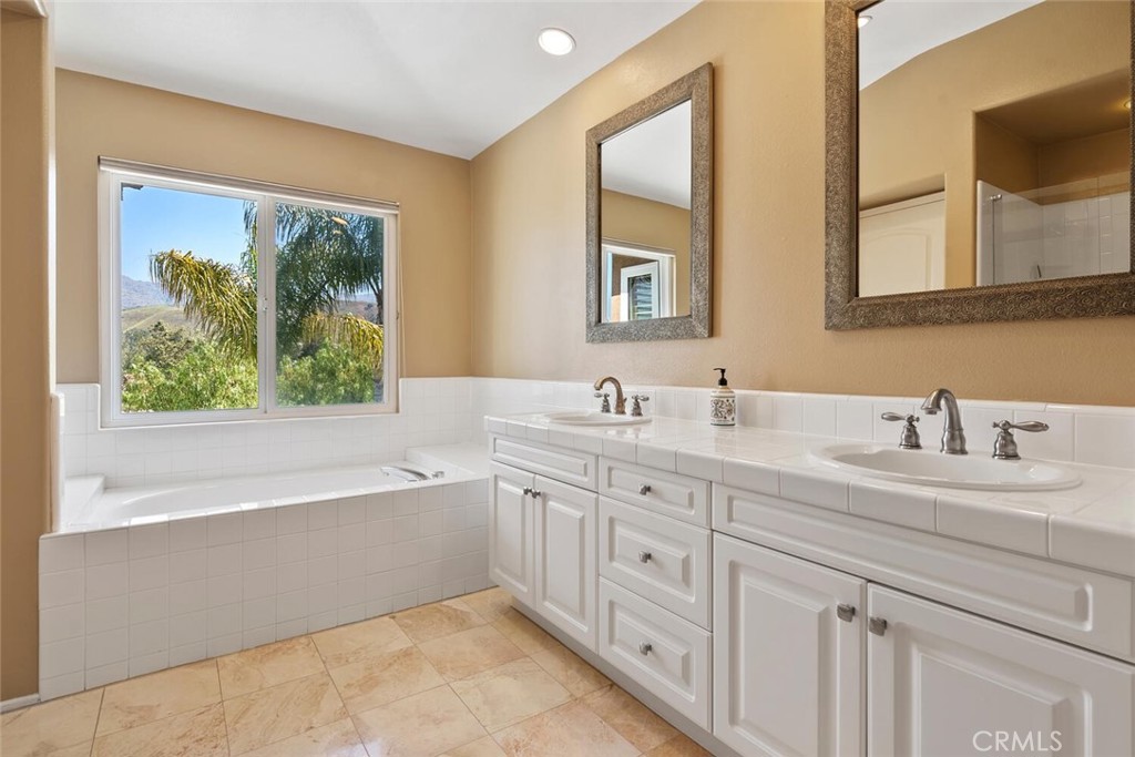 5149 Pesto Way Oak Park, CA 91377 - Photo 29 of 42 a bathroom with a granite countertop sink mirror and a bathtub