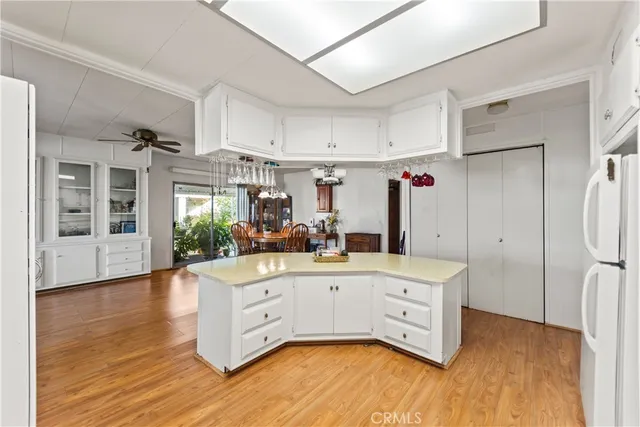 a kitchen with stainless steel appliances a white refrigerator cabinets and wooden floor