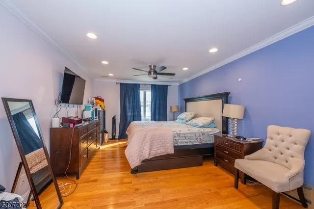 a spacious bedroom with a bed a couch and a flat screen tv